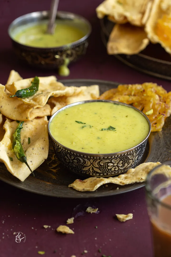 A bowl of yellow besan chutney with fafda